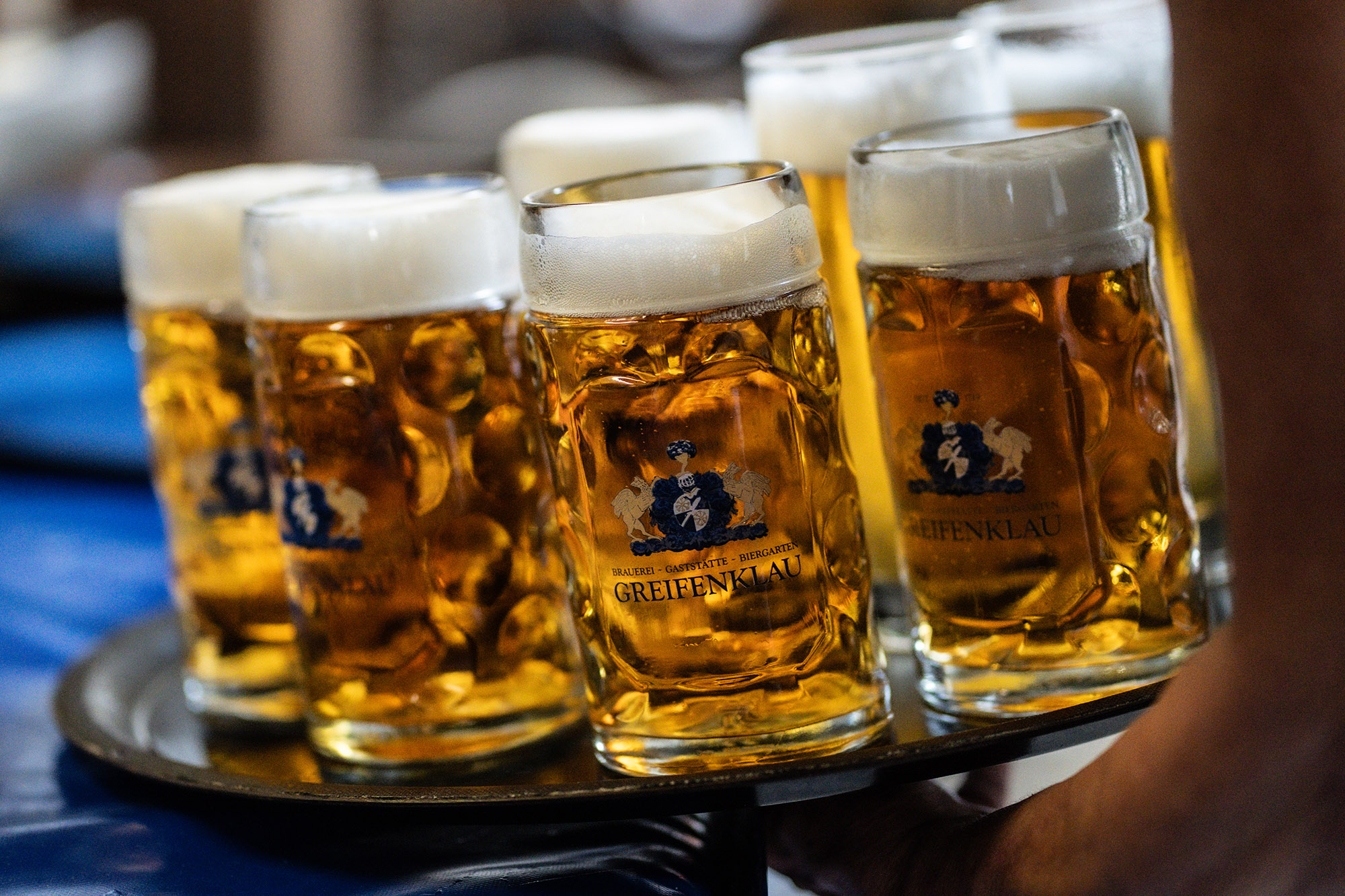 Bedienung nimmt Tablett mit Biergläsern auf